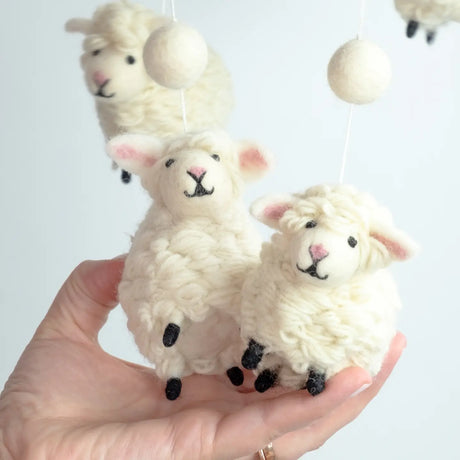 Hand holding Felt Mobile | Sheep with soft wool sheep figures hanging from a hoop for nursery decor.