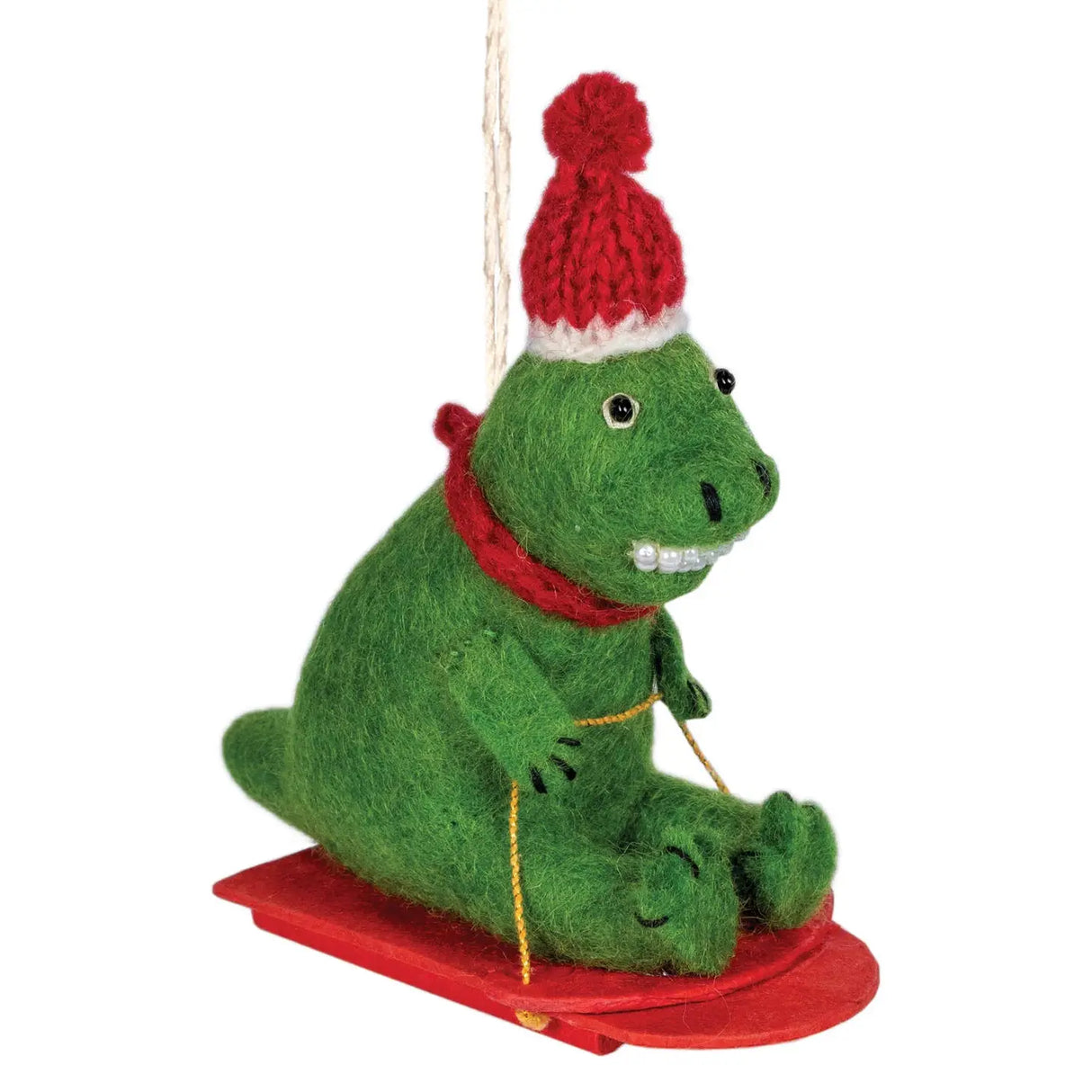 Sledding T-Rex Felt Ornament with red hat and scarf on a red sled, handmade with natural wool from Nepal.