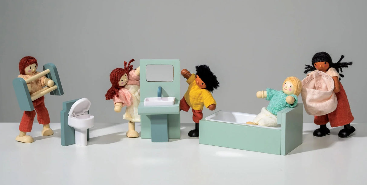 Miniature dollhouse bathroom set with bathtub, toilet, sink, and five diverse dolls playing together