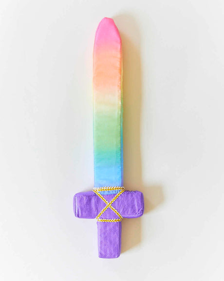 Soft fabric sword with a rainbow blade and purple handle decorated with yellow braided trim on white background