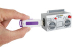 Hand inserting white and purple USB drive into small gray toy boombox with red and white details against white background