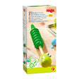 Green wooden slide whistle shaped like a smiling crocodile, designed for children aged two and up.