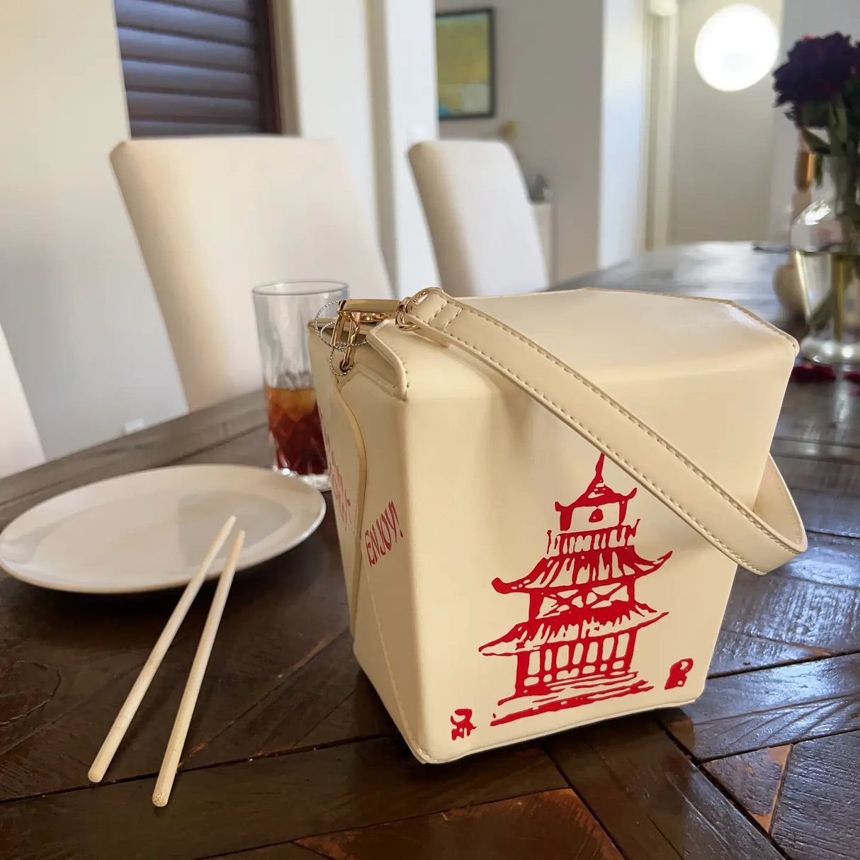 Handbag | Takeout Box shaped crossbody bag with red pagoda design on wooden table next to chopsticks and plate