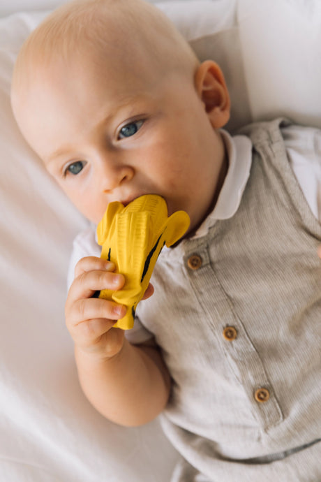 Baby chewing on Natural Teether | Ana the Banana Pop Art Edition, a soft, safe, hand-painted rubber teething toy.