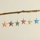 Colorful Floral Paper Star Ornament hanging from a branch
