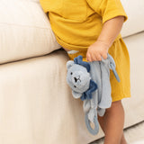 Baby holding a soft blue lion teether buddy with soothing teething rings and a gentle rattle toy accessory