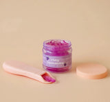 Small jar of grape jelly food with a pastel pink spoon and lid on a soft beige background for dolls.