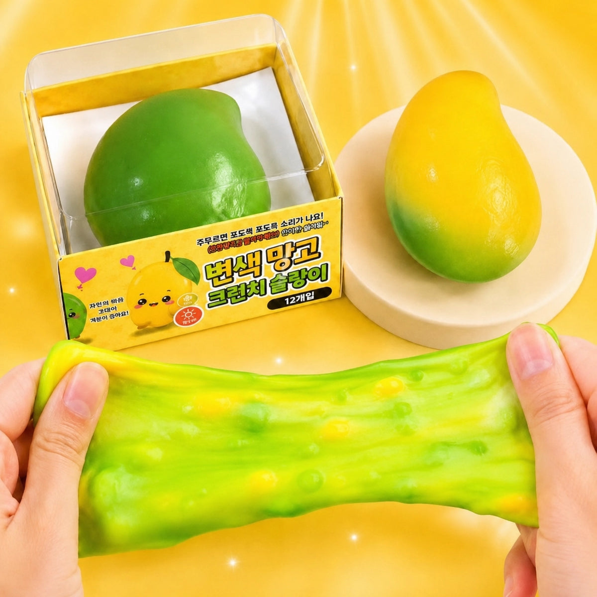 Magic Color Mango Crunch Squishy stretched between hands beside a mango-shaped toy and package
