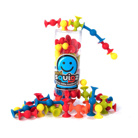 Squigz Mini colorful suction cup building toys displayed in a clear container and scattered below