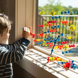 Squigz Mini colorful suction construction pieces on a window as a child plays