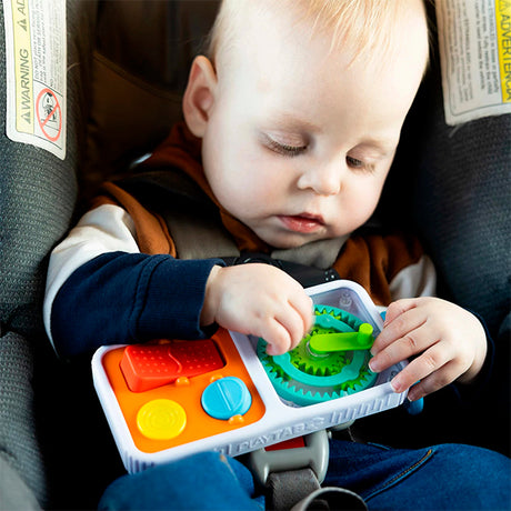 Baby playing with a colorful PlayTab Go sensory activity board clipped inside a car seat for on-the-go fun