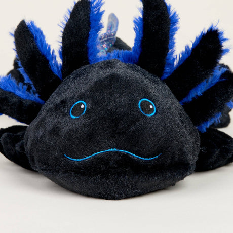 Close-up of a soft black and blue axolotl plush toy with embroidered facial features and fluffy gills