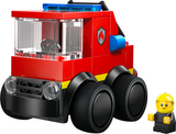 Mini red toy fire truck building kit with large wheels and a smiling firefighter figure for creative play.