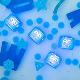Glo Pals | Blue Blair glowing blue light up bath cube among colorful bath toys