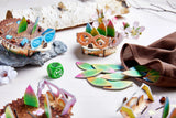 Colorful wooden hedgehog figures with leaves, dice, and cloth bag in a bright, playful memory game setup.