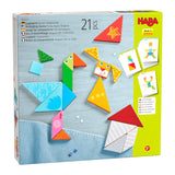 Colorful wooden tangram puzzle pieces with funny faces forming a bird, dog, and house on a play surface.