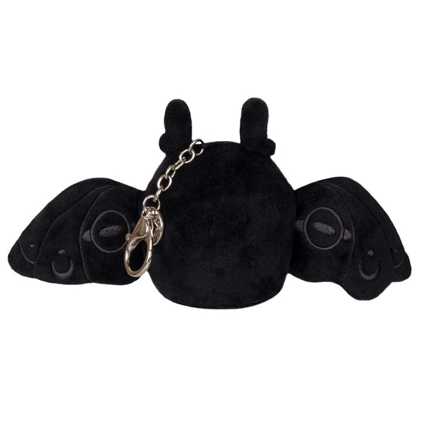 Plush micro moth-like creature viewed from behind with spread black wings and attached metal keychain clasp