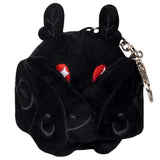 Small black plush creature with folded wings, red star-patterned eyes, and two leaf-shaped ears attached to keychain