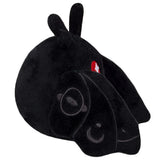 Black plush creature with long ears, antennae, and red eyes in a resting side pose