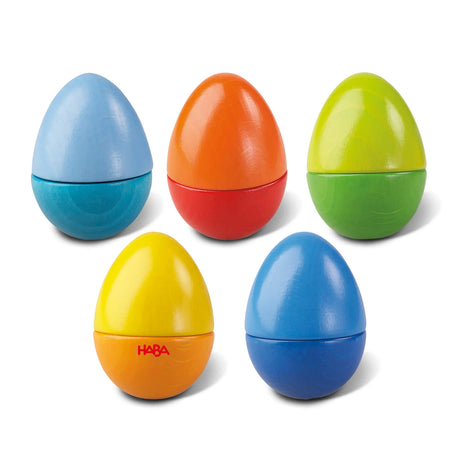 Set of five colorful wooden sensory eggs that make different gentle sounds for toddler play and exploration.