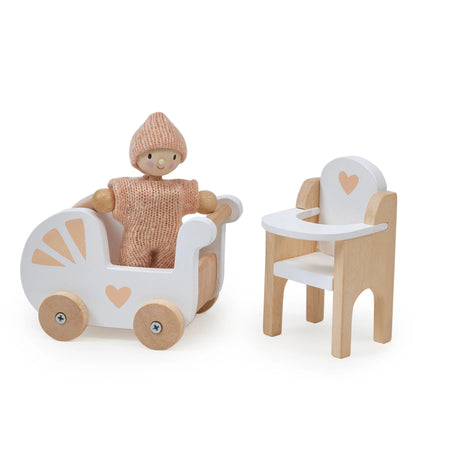 Wooden doll in knitted outfit sitting in white pram with wheels next to wooden highchair with heart design