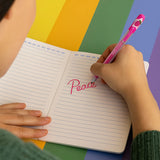 Write On: Notebook with a child writing Peace in pink ink