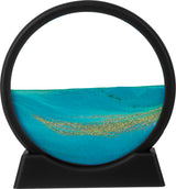 Sand Scene showing blue sand cascading to form serene mountain and valley patterns inside a round frame with black base.