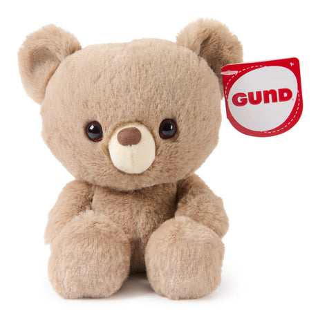 Small soft brown plush bear with round eyes and a red GUND tag on its ear designed for kids and gifting
