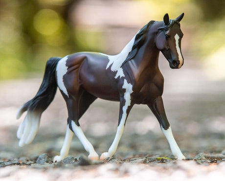 Pinto model horse in 1:12 scale from Freedom Series with detailed colorful coat and dynamic walking pose.