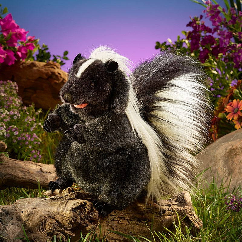 Standing Skunk Puppet perched on a log in a colorful garden
