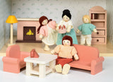 Miniature dollhouse sitting room with sofa armchair coffee table lamp fireplace and dolls in cozy setting