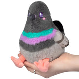 Pigeon Snackers gray plush pigeon toy with colorful striped body resting on a hand
