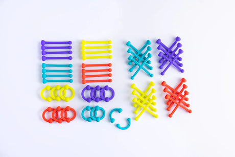 Plip Kit colorful silicone arches, sticks, and X's neatly arranged on white background for creative building.