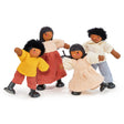Set of four wooden dolls dressed in colorful soft fabric clothing posing playfully on white background