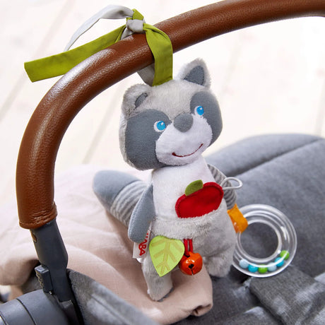 Willie Raccoon Hanging Toy attached to stroller, soft with bell, squeaky tail, and rattling ring for sensory play.