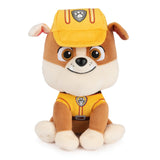 Soft plush puppy wearing yellow rescue hat and outfit sitting with cheerful expression