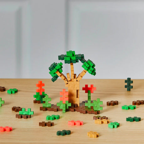 Plus Plus Jungle 240pc colorful building pieces creating a 3D tree and plants on a wooden surface.