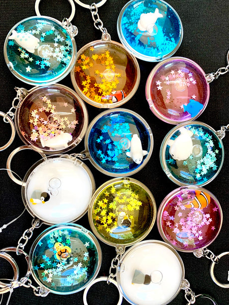 Floating Sea Charm KeyChain with assorted colorful floating sea creature designs and glitter inside clear round casing.