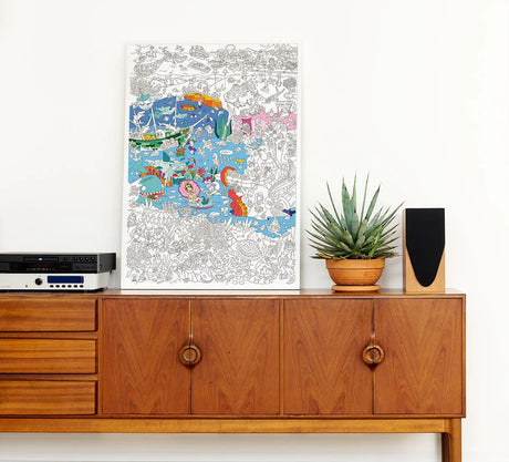 Ocean Giant Coloring Poster partially colored with underwater illustrations, displayed on wooden cabinet in modern room.