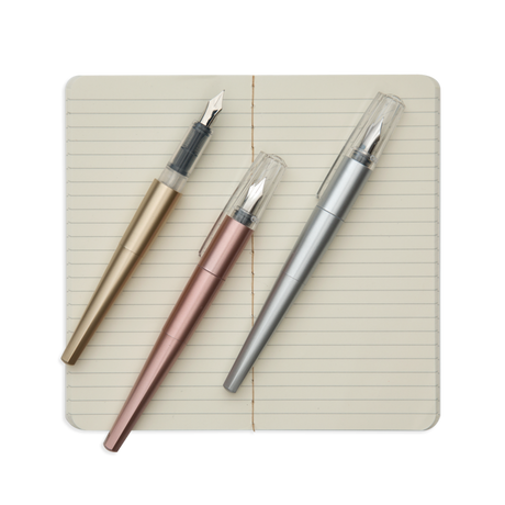 Modern Script Fountain Pens set with gold, rose gold, and silver pens on an open lined journal page.