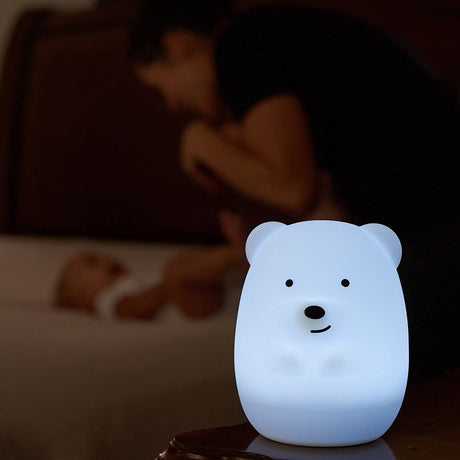LED Nightlight | Bear glowing softly on a table with a parent and baby in the blurred background.