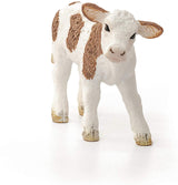 Simmental Calf figurine with white and brown markings, standing and looking forward in a friendly pose.