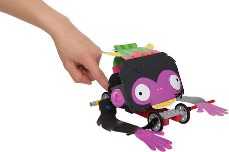 Hand turning crank of Lego Gear Bots yeti kinetic sculpture toy with paper character and LEGO base wheels.