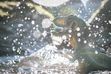 T Rex Green model roaring with water splashing around in a bright, natural outdoor setting.