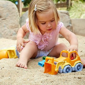 Child playing in sand with the Scooper toy truck, part of Green Toys™ eco-friendly construction set.