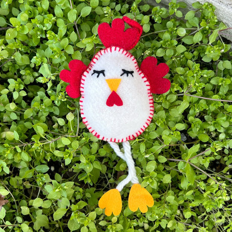 Chicken Felt Ornament handcrafted with white felt and red details, featuring dangling yellow feet on green leaves.