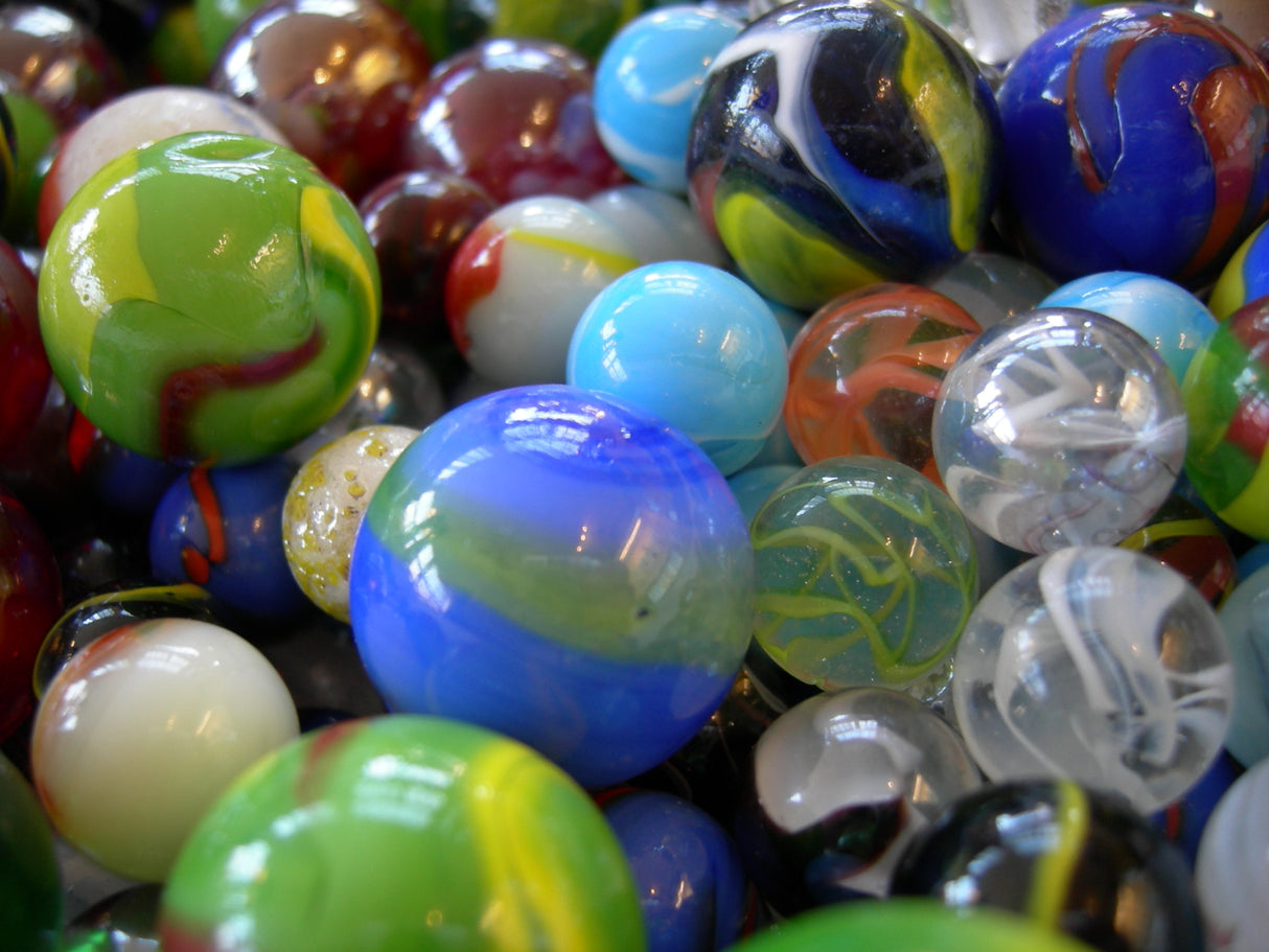 Marble Large assorted colorful glass marbles measuring 1.4 inches, sold individually with various swirls and designs.