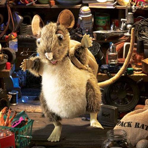 Soft fur Pack Rat Puppet with expressive eyes, twitchy nose, tail, and detachable pack in a detailed workshop setting.