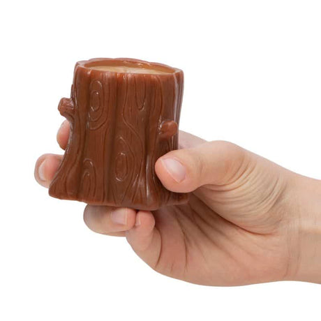 Hand holding a brown tree log toy for the Nutty Squirrel Popper that pops up a squirrel when squeezed.