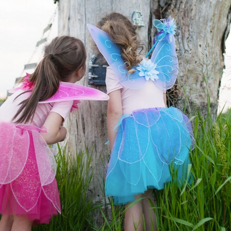 Fancy Flutter Skirt Set | Blue shown on a child wearing a blue glitter petal skirt, wings, and a matching wand outdoors.